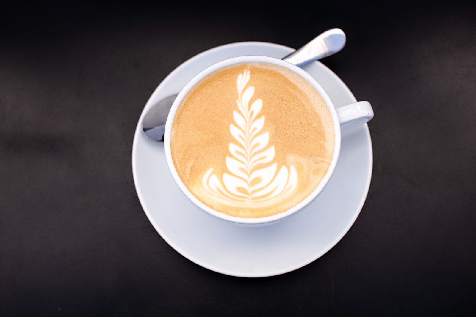 A freshly poured latte on a wooden counter