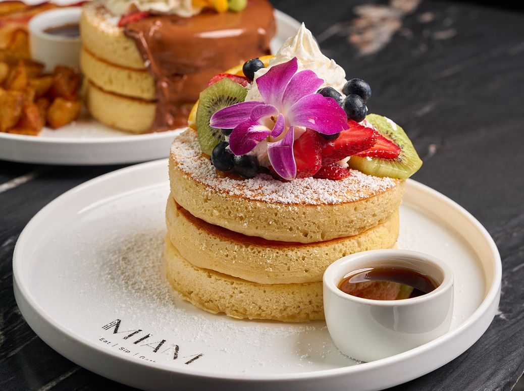 A towering stack of buttermilk pancakes